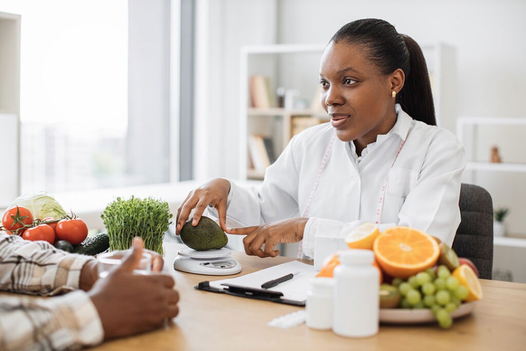 Dietitian pointing to an avocado to explain healthy choices