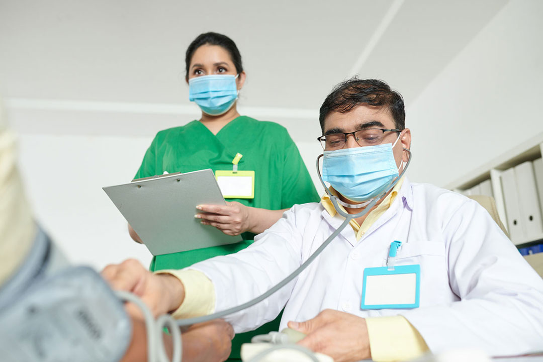 Two doctors beginning patient aftercare and checking on a patient